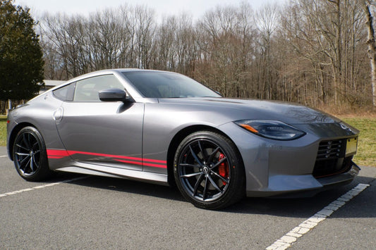 A Nissan Z car with a set of vinyl stripes decals applied on the side, parked on a road.